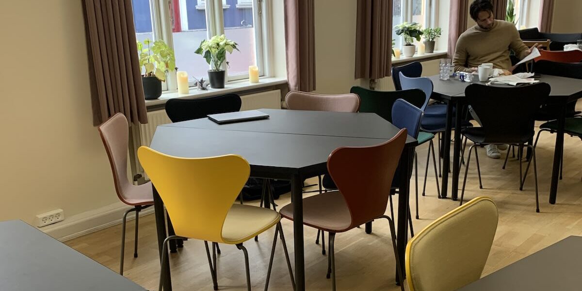 Indretning af lærerværelse på Laursens Real Skole Nye borde med linoleumsoverflade giver en rolig og varm fornemmelse, og polstrede stole i fem afstemte farver tilfører både komfort og et harmonisk helhedsindtryk.